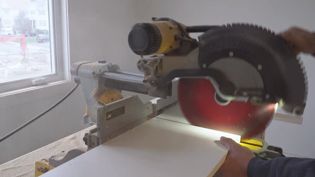 Carpenter at work using circular saw cutting wooden shelf board process for remodeling new hous