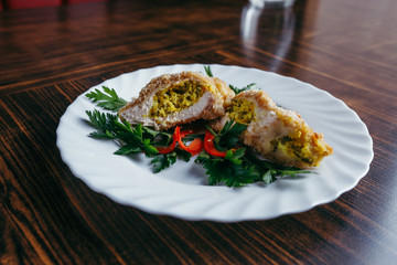 Chicken Kiev on croutons with mashed potatoes, on wooden table