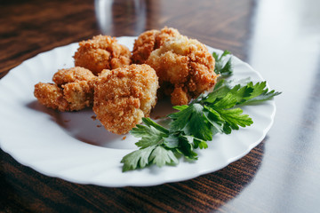 fried fresh cauliflower in breadcrumbs closeup on a plate.