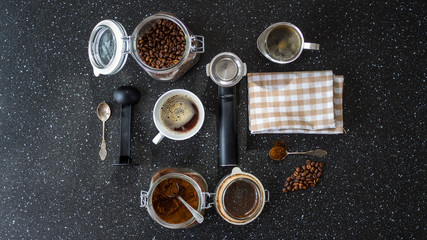 Składniki do przygotowania kawy leżące na czarnym stole