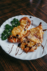 Chicken breast. cheese and onion chopped fritters served with stew green beans and tomatoes on white dish on chopping board