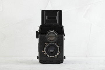 The old medium format film TLR camera, camera for modern lomography on white cement background. - obrazy, fototapety, plakaty