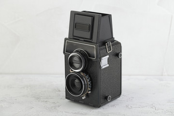 The old medium format film TLR camera, camera for modern lomography on white cement background.