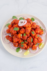 Indian Style Roasted Potatoes / Tandoori Aloo with Onion RIngs and Lemon Wedges Vertical Photo. Vegetarian Indian Appetizer.