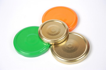 Screw caps for glass jars. For canning, canned food. Orange, green, golden caps on white background