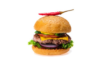 Tasty cheeseburger grilled cutlet, sesame bun,  tomato, onion, fresh lettuce and red chili peppers isolated on white background. Fastfood concept