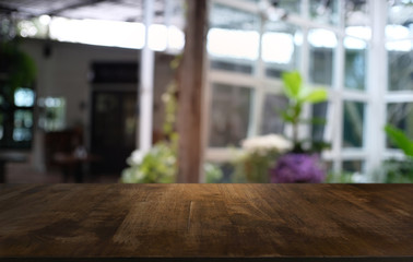 Empty dark wooden table in front of abstract blurred bokeh background of restaurant . can be used for display or montage your products.Mock up for space.