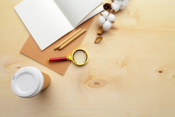 Beige color modern workplace on wooden table with a lot of things on it. Top view