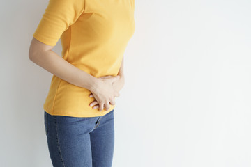 Young asian woman having painful stomachache on white background.Chronic gastritis. Abdomen bloating concept.