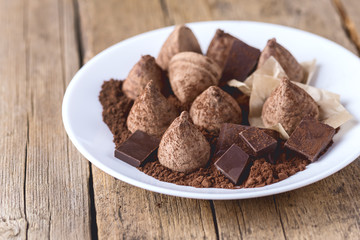 Homemade Chocolate Truffles With Cocoa Powder on a White Plate Old Wooden Background Tasty Candy Horizontal