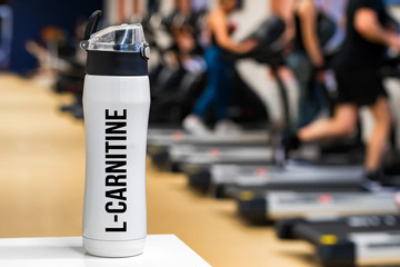 Plastic bottle or cup with L-Carnitine drink close up