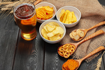 Lager beer and snacks on wooden table.
