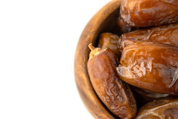 Dried of sweet dates palm fruits on wooden bowl on white background. Dates is a dried fruit that provides high energy.