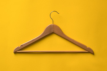 Wooden Clothes hanger on yellow background.