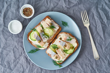 Herring smorrebrod - traditional Danish sandwiches. Black rye bread with herring on dark gray...
