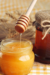 Honey background. Sweet honey in glass jar on wooden background.