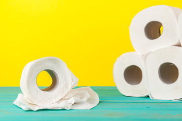 Toilet paper stacks  on bright yellow background