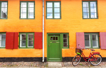 Fototapeta na wymiar Colorful house and parked bicycle in historical area of city