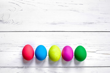 Colorful Easter eggs on white wooden background