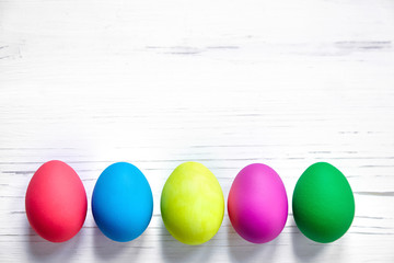 Colorful Easter eggs on white wooden background