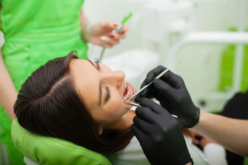 The dentist man are treating teeth to client in dental office