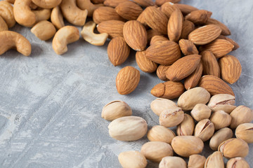 mixed nuts on a gray background. Walnut, pistachios, almonds, hazelnuts and cashews, walnut.