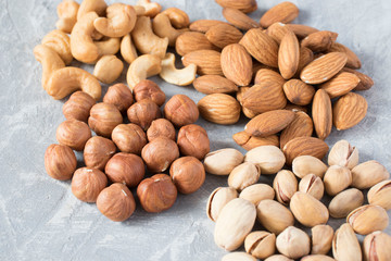 mixed nuts on a gray background. Walnut, pistachios, almonds, hazelnuts and cashews, walnut.