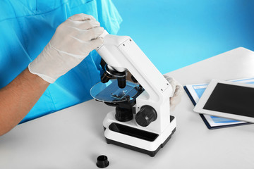 Male doctor using microscope at table, closeup. Medical object