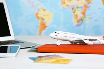 Composition with toy plane and laptop on table against map. Travel agency