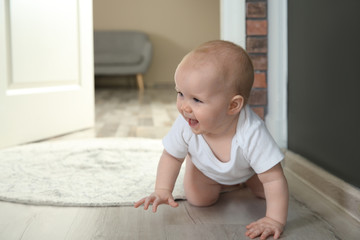 Fototapeta premium Cute little baby crawling on floor indoors, space for text