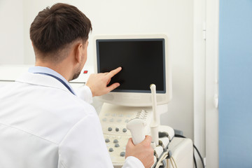 Fototapeta na wymiar Professional sonographer using modern ultrasound machine in clinic