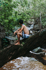 boy back to the landscape, man relaxing in the landscape, young boy exploring the landscape of rocks, river and trees