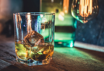 A glass of whisky on rough wooden background