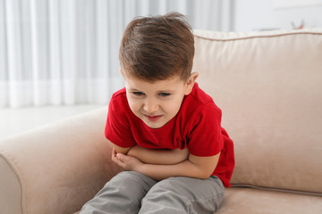 Little boy suffering from nausea in living room