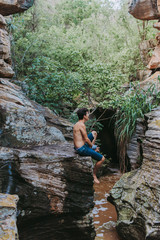 boy back to the landscape, man relaxing in the landscape, young boy exploring the landscape of rocks, river and trees