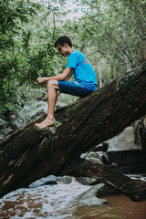 boy back to the landscape, man relaxing in the landscape, young boy exploring the landscape of rocks, river and trees
