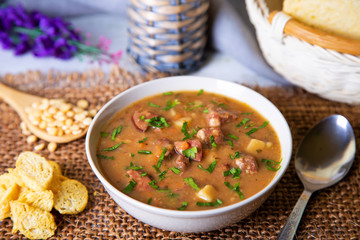 Peas soup with meat, smoked sausage and croutons. Selective focus, close-up.