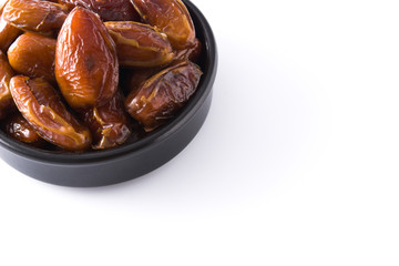 Dates in black bowl isolated on white background. Copyspace