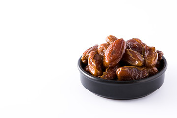 Dates in black bowl isolated on white background. Copyspace