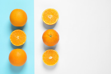 Flat lay composition with ripe oranges and space for text on color background