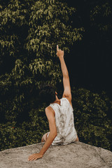 boy sitting relaxing in nature, man next to many trees, young man observing the trees