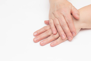 The hands of an elderly woman on a white background which has skin problems, dry and cracked skin on the hands, wrinkles, close-up, isolate, copy space, elasticity