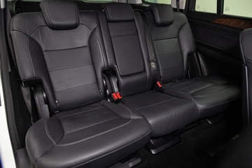 Interior view with rear seats of luxury very expensive new white SUV car stands in the washing box