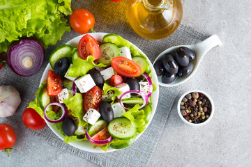 Fresh Greek salad made of cherry tomato, ruccola, arugula, feta, olives, cucumbers, onion and...