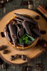 Chocolate cakes on black slatter board with mint, coffee beans on dark background, closeup photo. Fresh, tasty dessert food concept. 