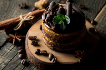 Chocolate cakes on black slatter board with mint, coffee beans on dark background, closeup photo. Fresh, tasty dessert food concept. 