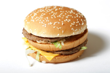 Close-up of a delicious fresh burger with lettuce, cheese and onions on a white background