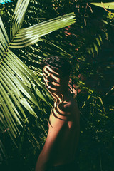 Portrait conceitual of young and beautiful man with dark shades in tropical leaves / stylish hipster man with palm leaf embracing. boy portrait with natural herb, boho sensual. romantic moment. rustic