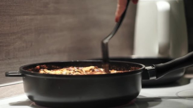 Stirring mussles in a tomato sause