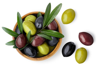 Delicious black, green and red olives with leaves in a wooden bowl, isolated on white background, view from above